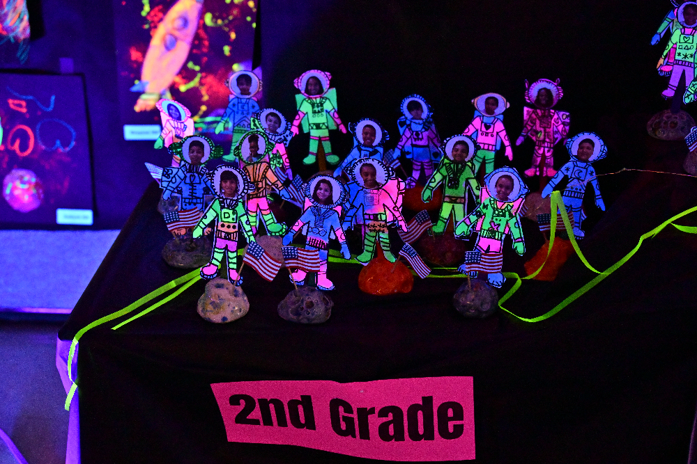 Glow art showing 2nd grade students as astronauts