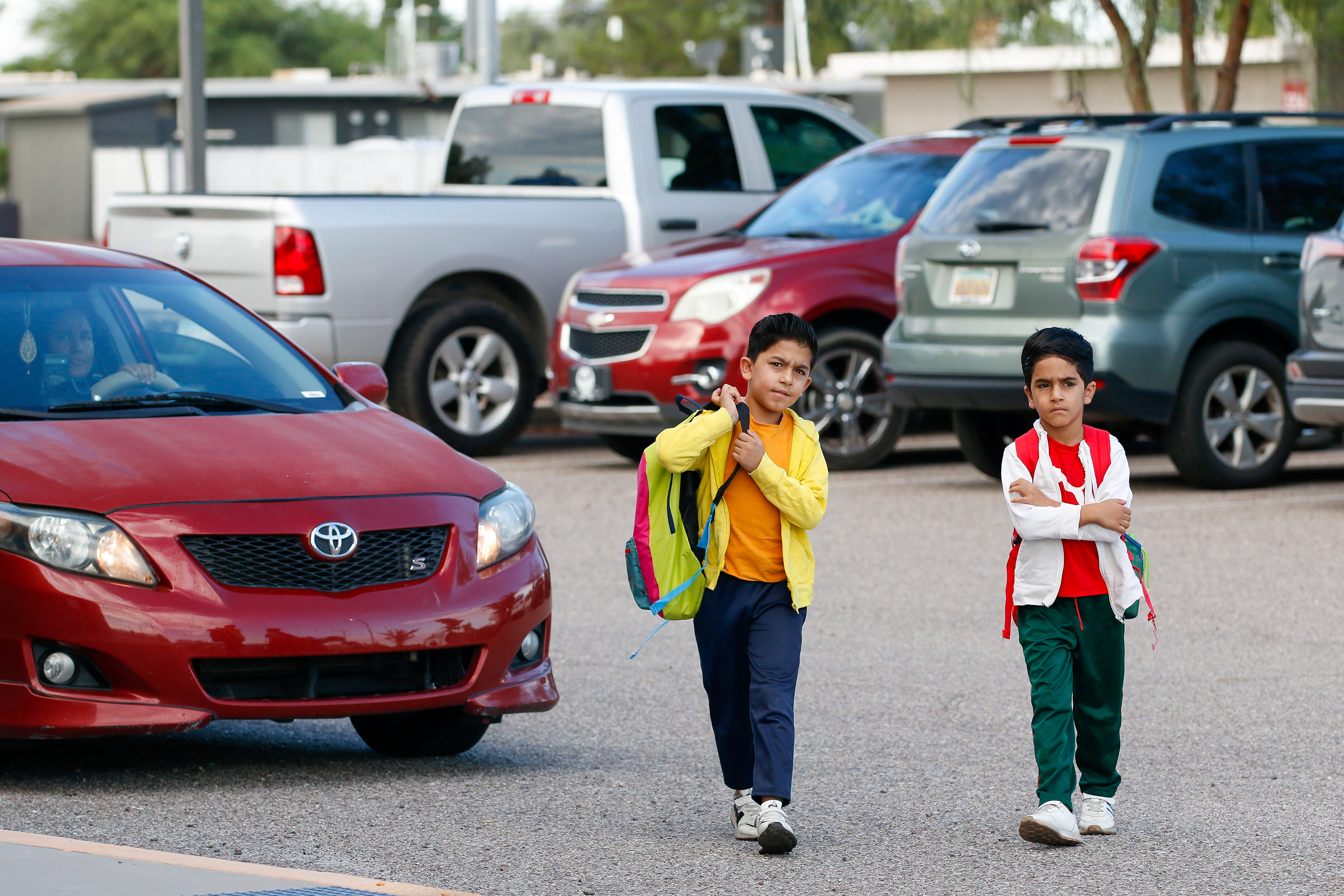 Two boys walk from the parking lot into school on the second day