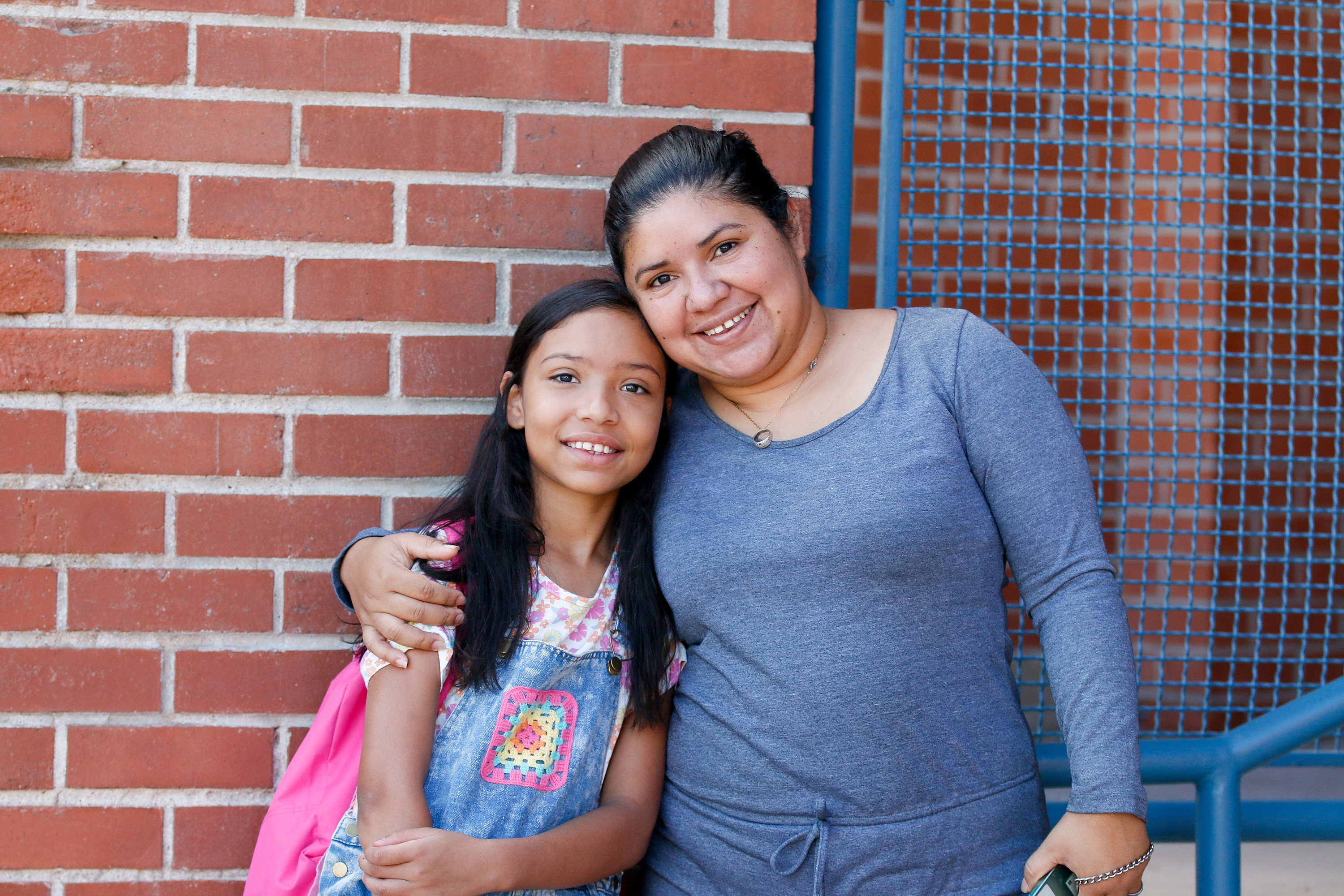 A mom and daughter smile and hug outside Erickson