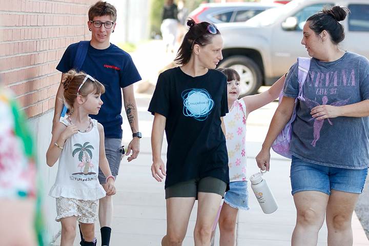 Two girls and their family walk in from the parking lot on the second day of school